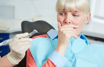 anxious woman with fear of dentist before dental treatment