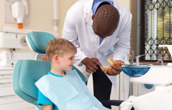 pediatric dentist educating little boy on oral health