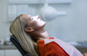relaxed sedated woman in dental chair