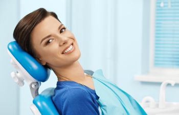 relaxed smiling woman in dental chair before treatment